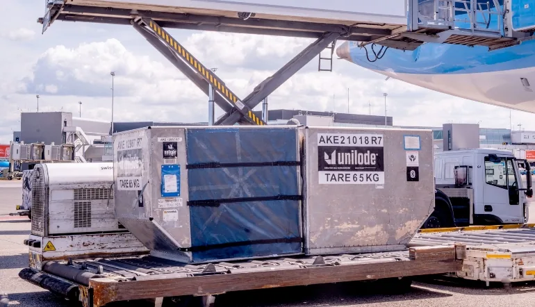 A Unilode-branded unit load device on airport loading equipment beneath an aircraft